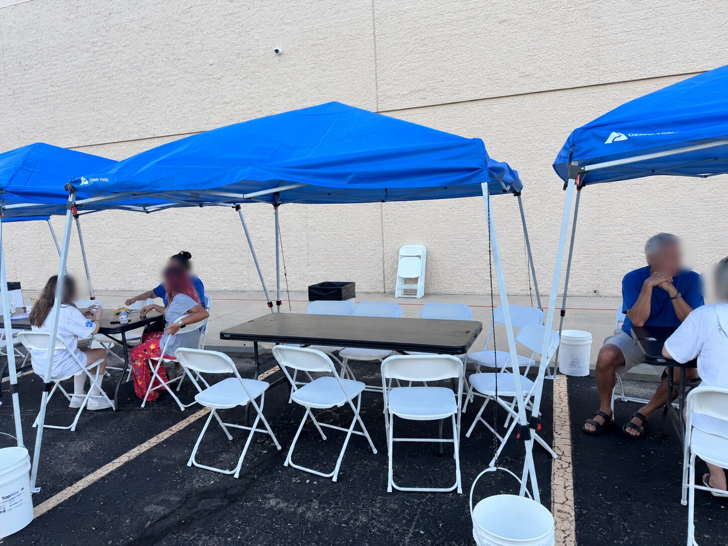 Blue event tents, folding chairs, and tables at the Trunk Collections fundraiser in Thornton
