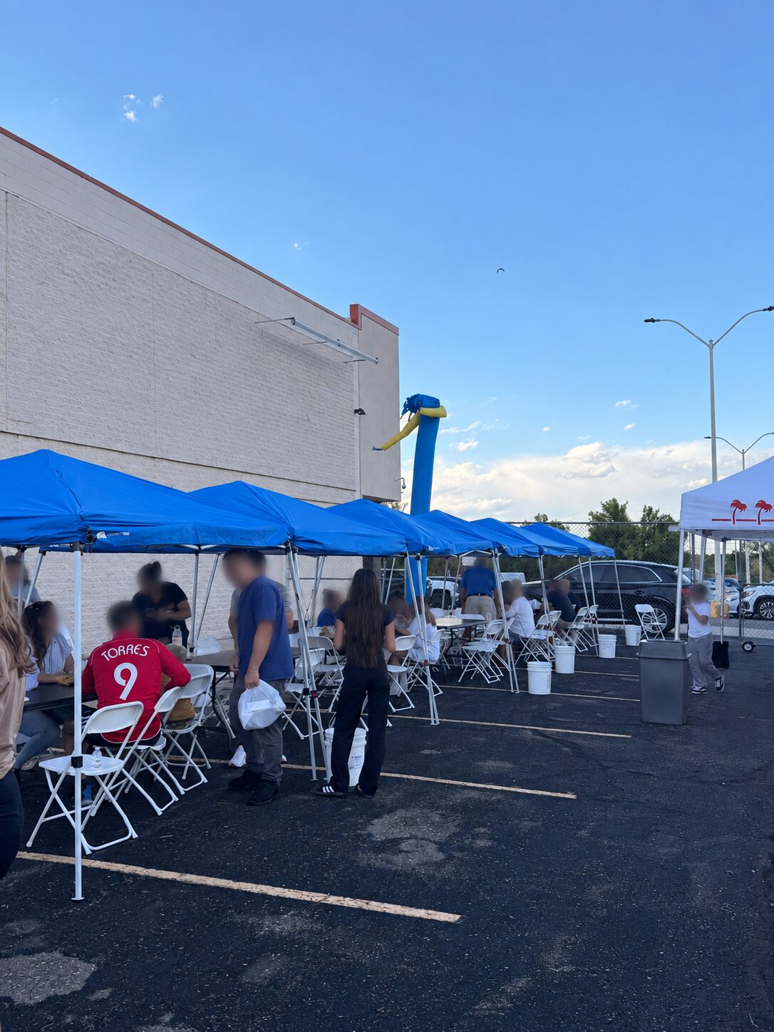 Community fundraiser guests gathered beneath blue tents at Washington Plaza